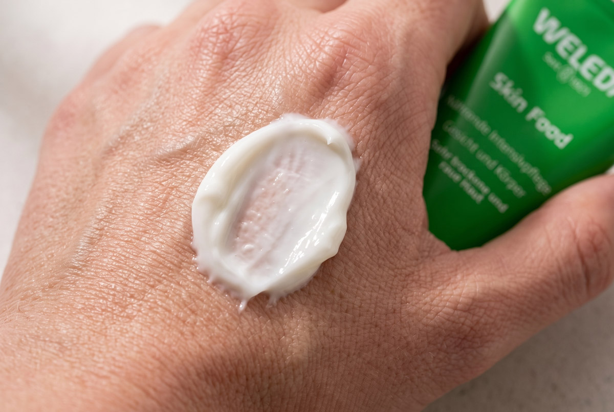 Reichhaltige Textur der Weleda Skin Food auf dem Handrücken
